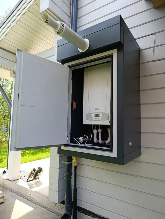 Уличный газовый котёл BAXI в защитном шкафу на фасаде дома